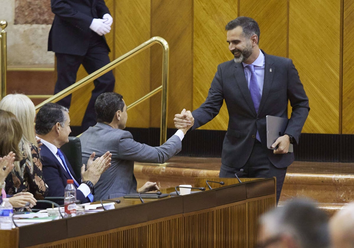 El presidente, Juanma Moreno, saluda al consejero de Sostenibilidad, Ramón Fernández-Pacheco tras la aprobación de la ley