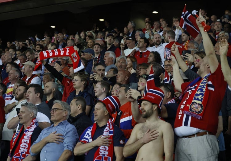 Los aficionados noruegos, alguno descamisado, escuchando su himno antes del partido de este sábado.