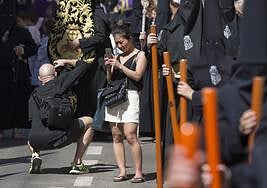 Una turista inmortaliza una procesión de Semana Santa de la capital.