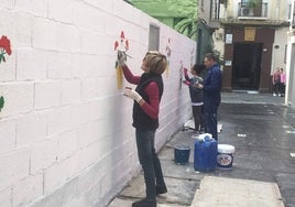 Macetas y pinturas llenan las paredes de algunas de las calles de este barrio del Centro malagueño.