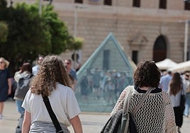 Turistas se dirigen hacia su alojamiento en la capital malagueña.