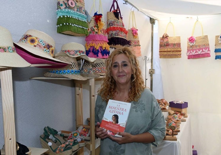 Lola, con los bolsos que cose a mano y su segunda novela, 'La maestra gitana', en el mercadillo de Puerto Banús