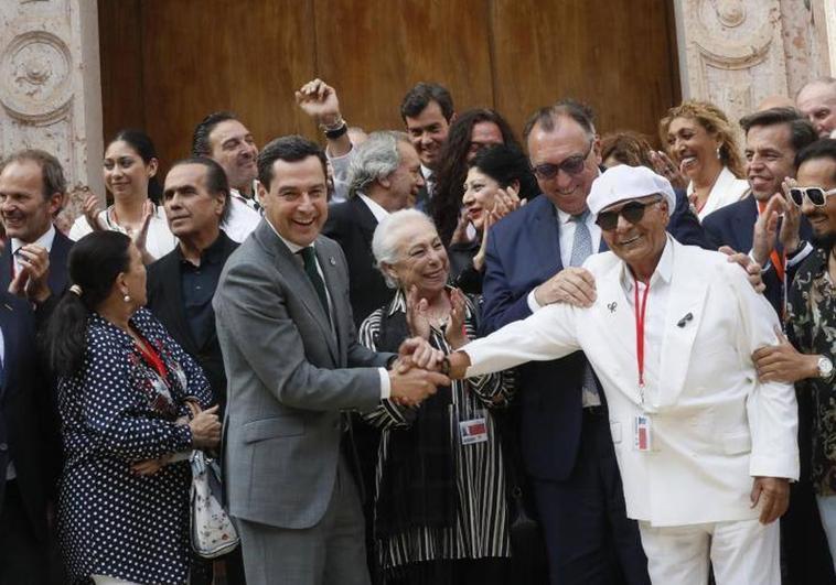 Juanma Moreno, junto a representantes del Flamenco tras la aprobación de la ley en el pleno del Parlamento andaluz.