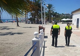 Dos agentes de la Policía Local de Nerja, patrullando a pie por el paseo de Burriana.