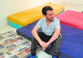 El artista Enrique Res, en el espacio de la cafetería donde están los colchones para que los alumnos descansen.