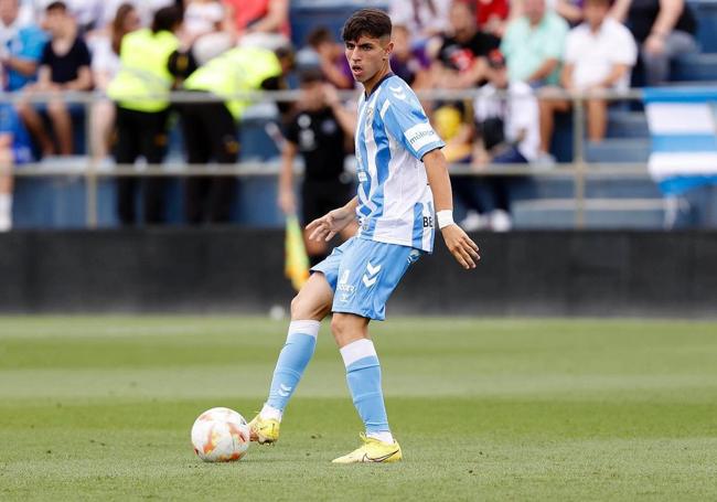 Izan Merino en un partido con el filial del Málaga y posando con la camiseta de la selección española.