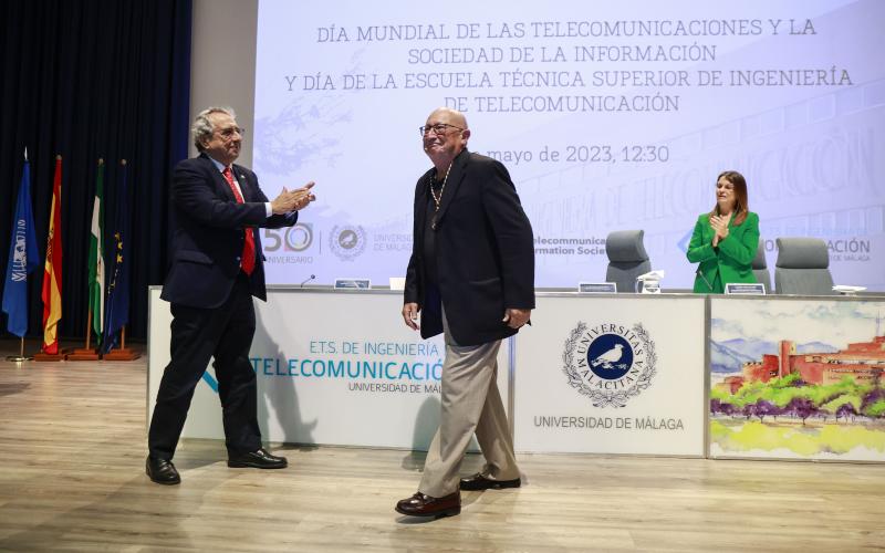 El profesor García Lopera recibe el aplauso del rector tras imponerle la medalla de honor.