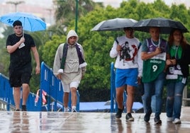 Aficionados al Unicaja, ayer de camino al partido bajo la lluvia.