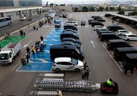 Taxis, VTC y vehículos de enlace de 'rent a car' y aparcamientos de larga estancia, en la zona de precontratación.