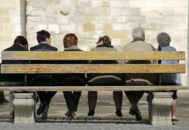 Un grupo de personas mayores sentadas en un banco.