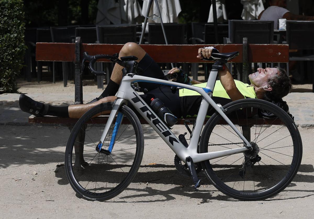 Un joven descansa junto a su bicicleta, este lunes