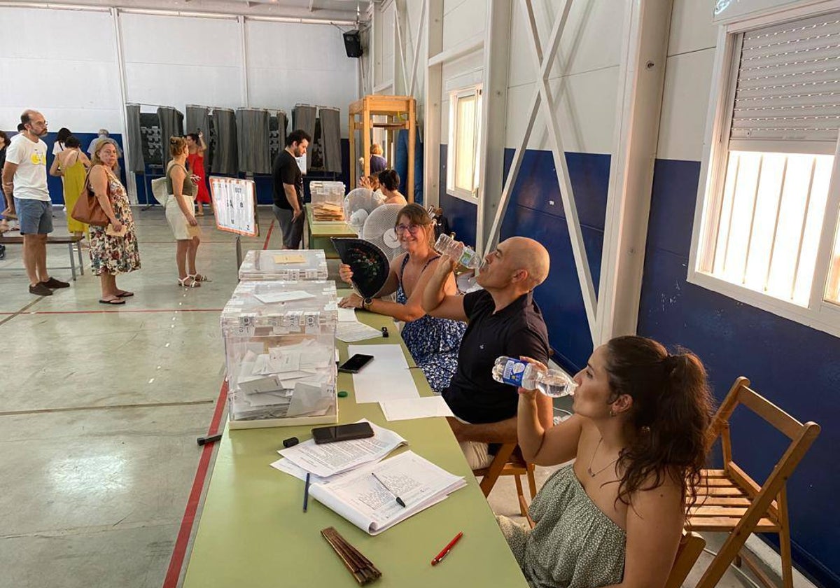 Miembros de una mesa electoral del Colegio San Manuel tratan de aliviar el calor con ventiladores, abanicos y mucha agua.