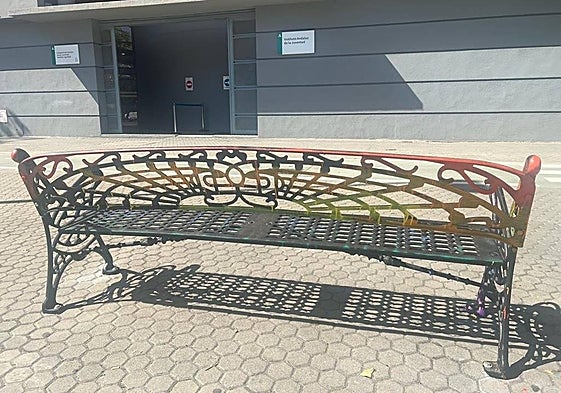 El banco rociado con tinta negra aún muestra restos de la bandera arcoíris.