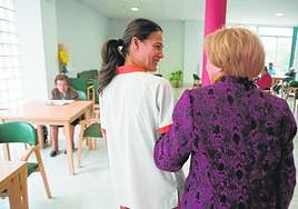 Una persona mayor es atendida por una auxiliar en una residencia, una de las prestaciones que se ofrece desde la dependencia.