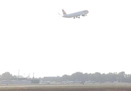 Un avión comercial despega sobre la zona de estacionamiento de aviones ejecutivos en el Aeropuerto de Málaga.