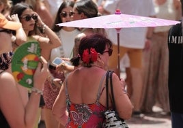 Una visitante se protege del sol bajo una sombrilla en la reciente feria.