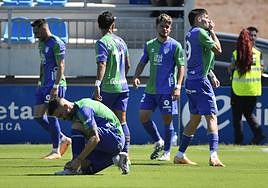 Roberto besa el escudo del Málaga tras marcar su gol ante el Atlético Baleares mientras Dioni se anuda las botas.
