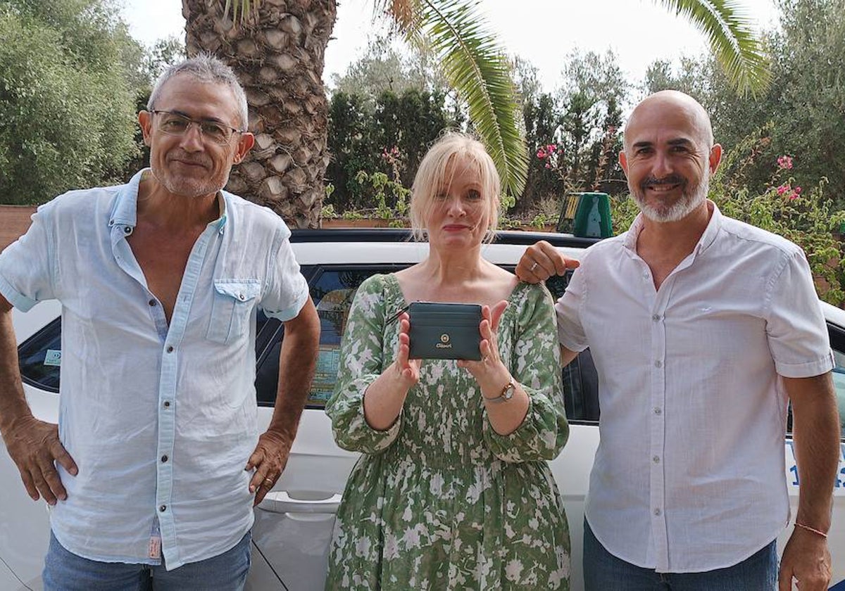 El taxista Rafael Calderón y el policia local Paco Martín junto a la propietaria de la cartera