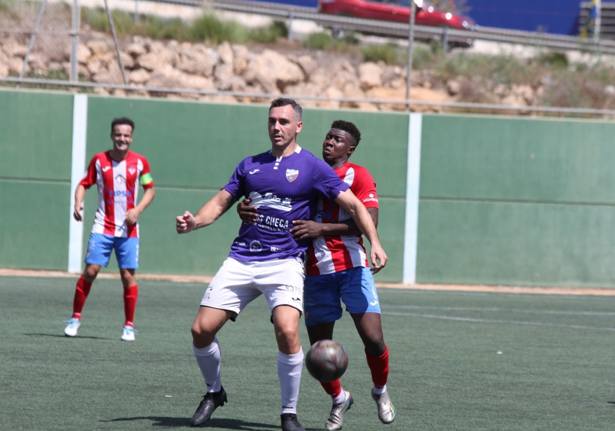 Antonio López delantero del UD Torre del Mar intentando controlar un balón.