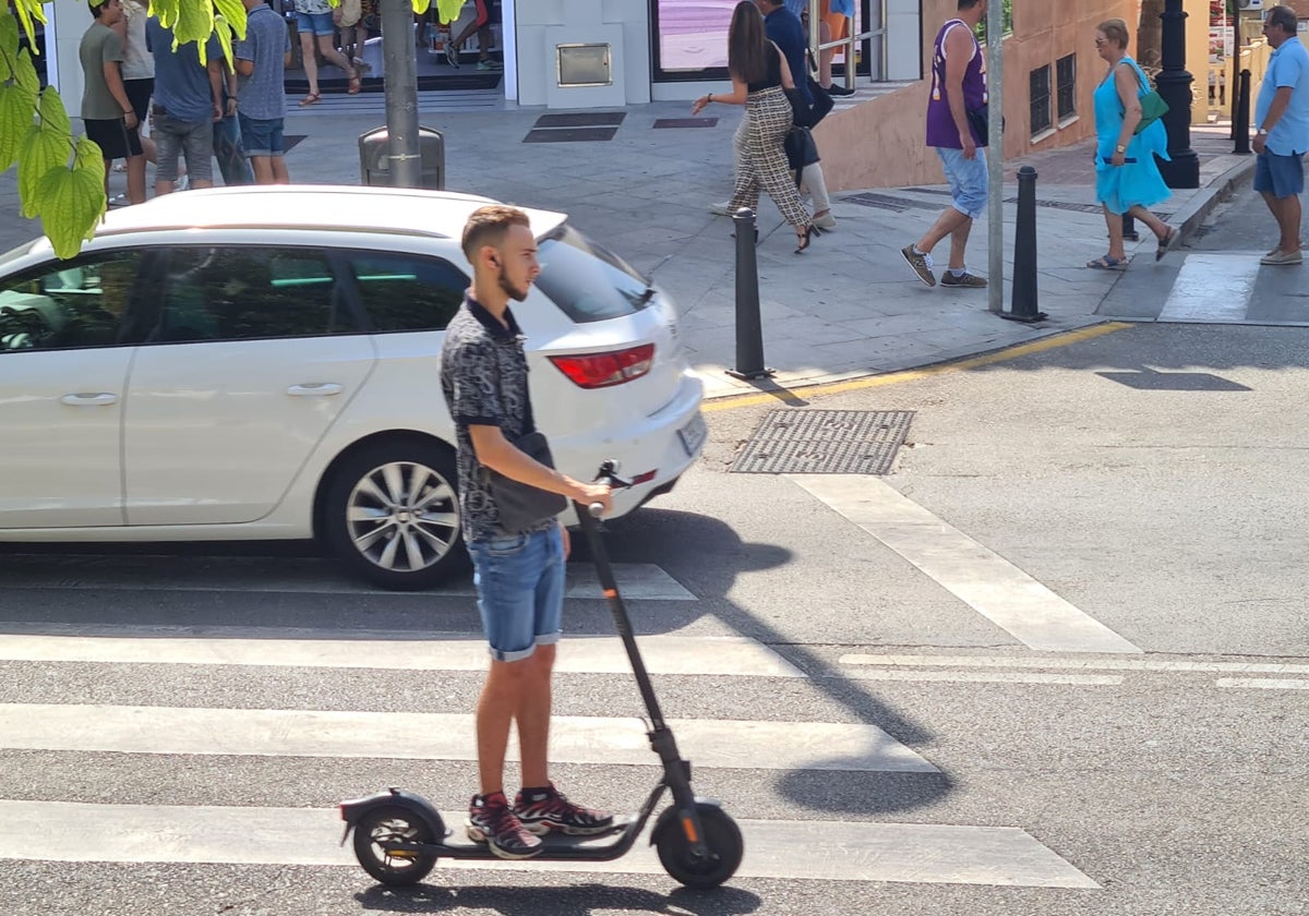 Joven circulando en un patinete.