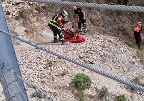 Efectivos de Bomberos y de Protección Civil asisten al herido, este domingo en Canillas de Aceituno.