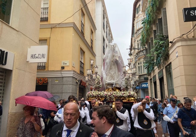 La imagen ha sido protegida con un plástico cuando ha comenzado a llover en calle Nueva.