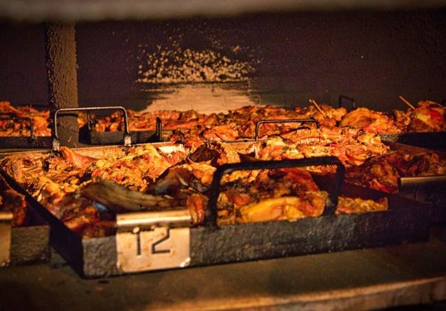 Chivo al horno de leña en bandejas en Bodegón Juan María.