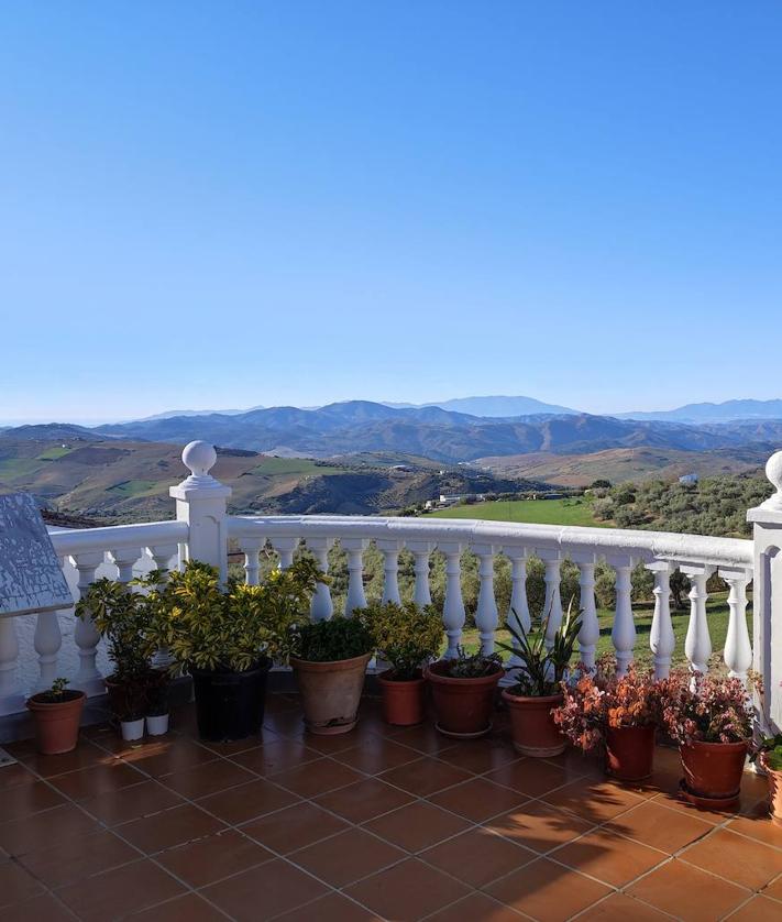 Imagen secundaria 2 - Hay decenas de fotografías en las paredes de una pequeña sala. Abajo, en el interior hay un lienzo de la Virgen de la Purificación, que se procesiona cada 25 de diciembre. Y vistas panorámicas desde la entrada a la ermita.