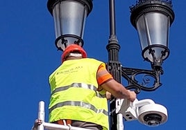Un operario instala un videosensor en una farola.