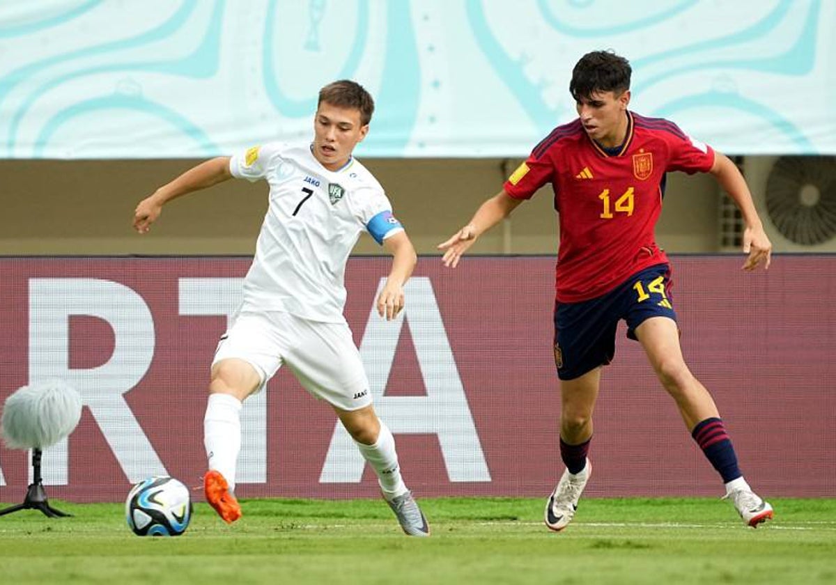 Izan Merino pelea un balón con un jugador uzbeco.