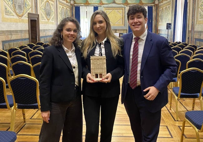 Rubén Martín, junto a dos compañeras, posa con un galardón.