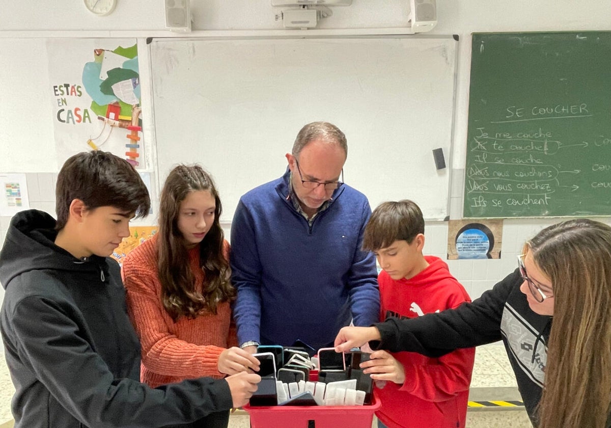 Javier Risoto, profesor de Geografía e Historia en Marista, recoge los móviles de sus alumnos para guardarlos durante el horario escolar.