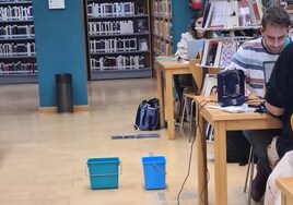 Cubos para recoger el agua que cae de las goteras en la sala de estudios.