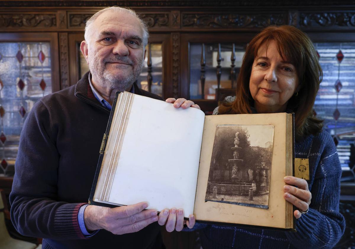 Imagen principal - En la primera imagen, Juan Antonio Fernández Rivero y Teresa García Ballesteros sostienen el álbum por la página que incluye la foto tomada en Málaga en 1851. En la segunda, detalle de la cerradura J. Bramah, la más prestigiosa de la época, que guarda las imágenes como un tesoro. Y en la última, el álbum de piel marroquí del viaje a España de los Tenison.