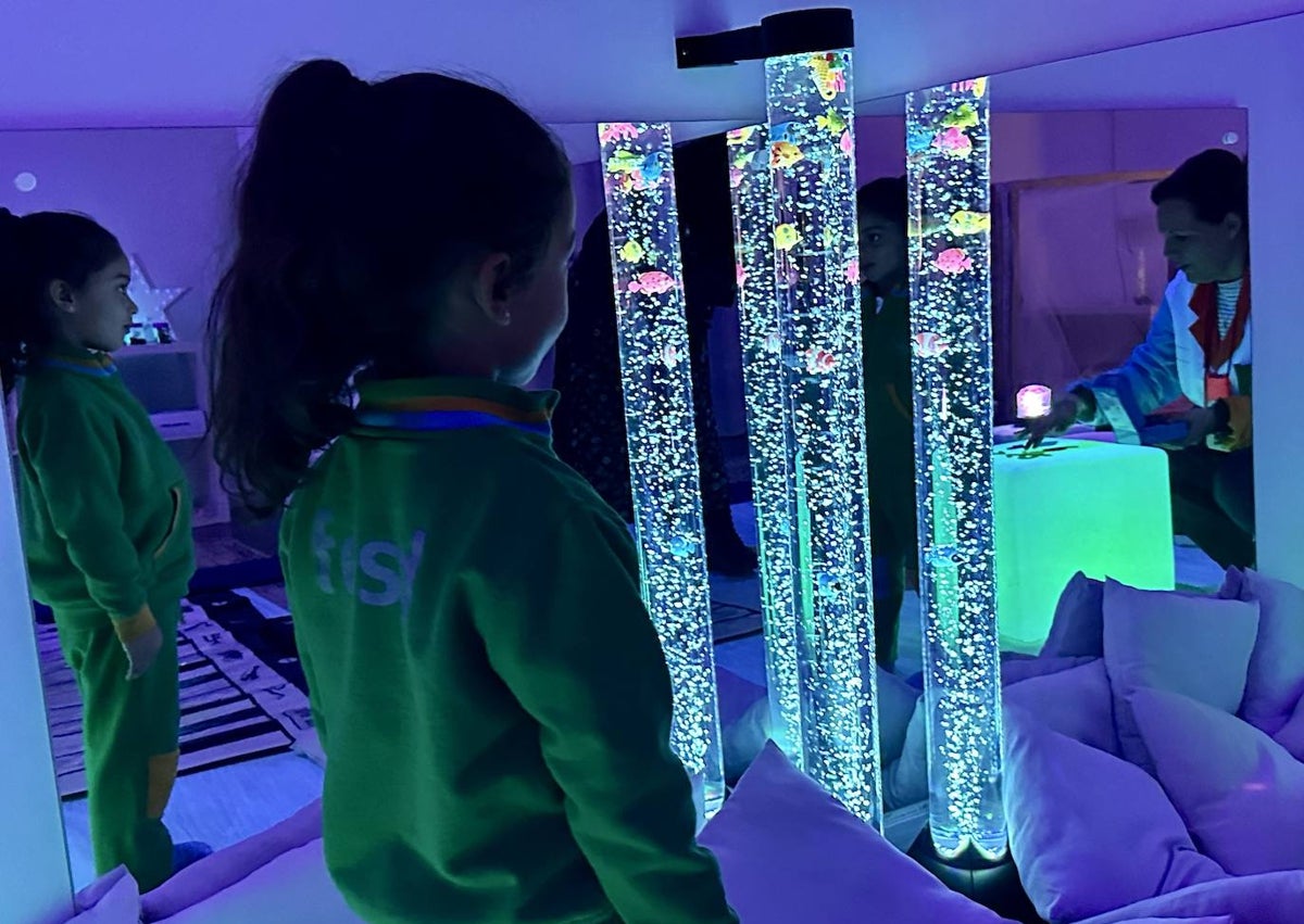 Imagen secundaria 1 - La maestra Almudena Rivas, junto a una alumna; una alumna observa las columnas de burbujas y un alumno enseña unas gafas fluorescentes.