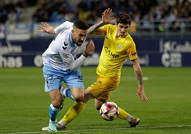 Dioni, que fue expulsado, encara a un jugador rival.