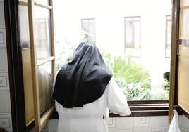 Introspección. Una religiosa se asoma a la ventana de un convento.