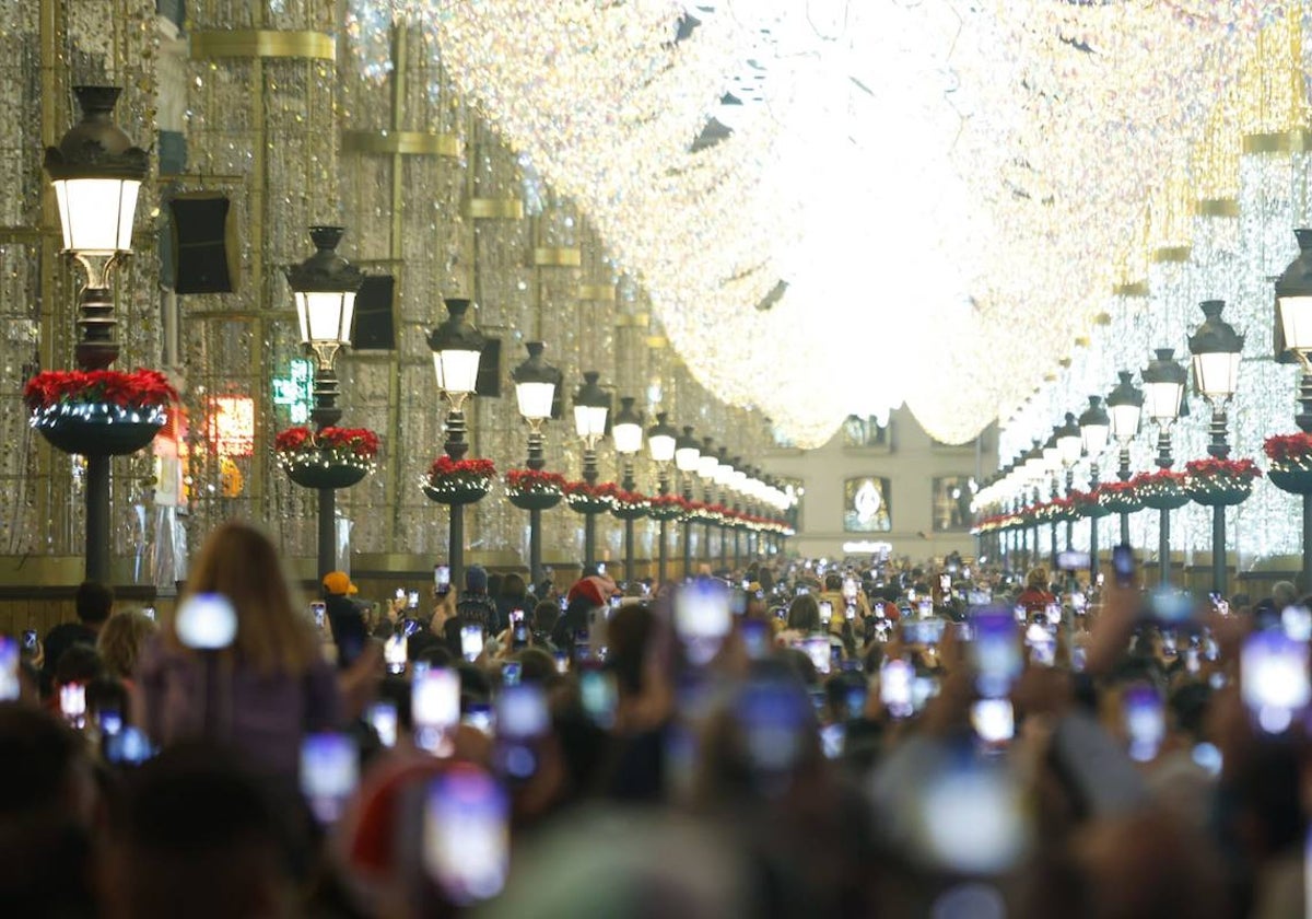 Turistas y residentes disfrutan del espectáculo de música y luces de Navidad en Málaga.