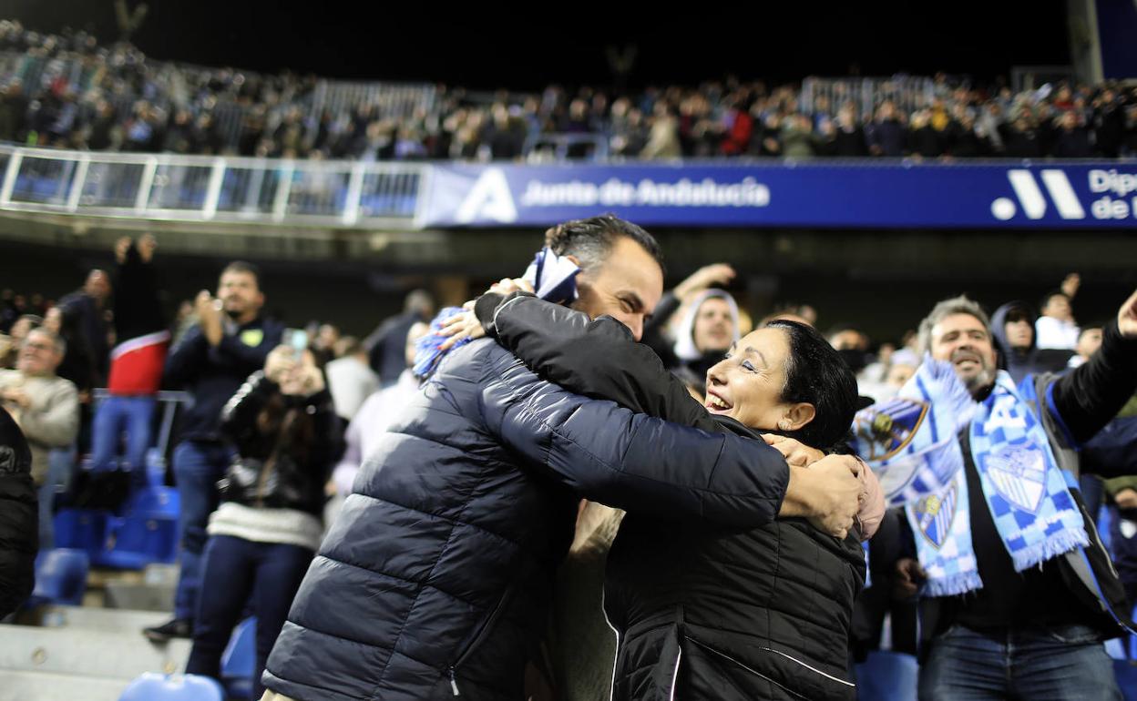 Dos aficionados se abrazan para celebrar un gol del Málaga ante el Alavés, en la última cita de local del equipo esta temporada. 