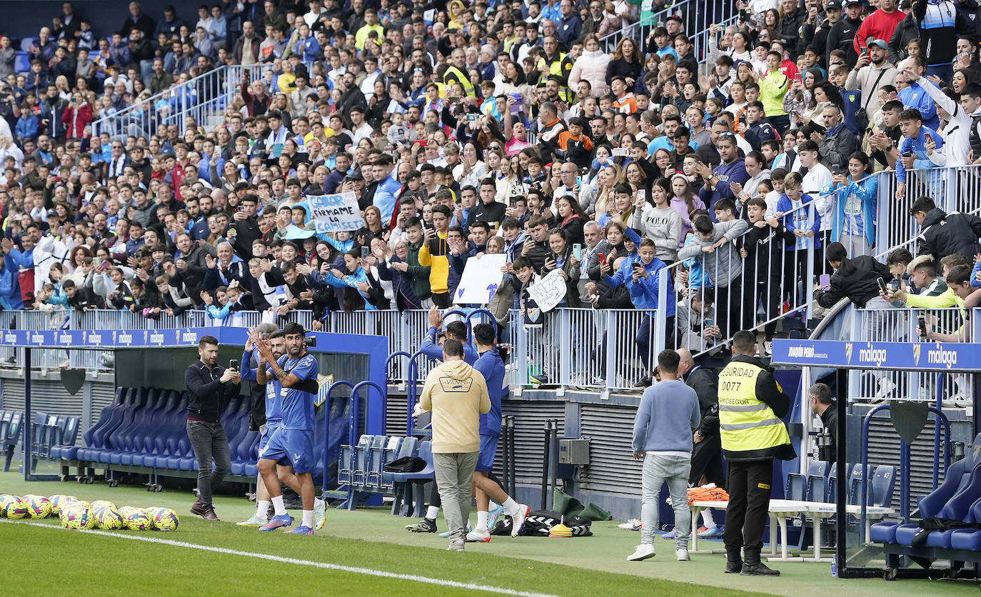 Miles de seguidores, entre ellos muchos niños, acuden en masa a La Rosaleda para ver una sesión de trabajo del equipo blanquiazul en la víspera del Día de Reyes. 