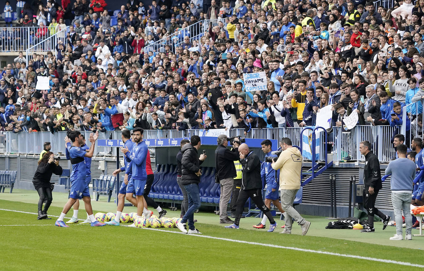 Miles de seguidores, entre ellos muchos niños, acuden en masa a La Rosaleda para ver una sesión de trabajo del equipo blanquiazul en la víspera del Día de Reyes. 