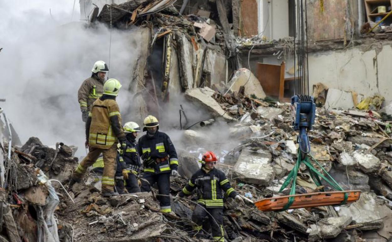 Rescatistas retiran el cuerpo de una víctima entre los escombros de un edificio residencial de Dnipró tras un ataquea aéreo ruso. 