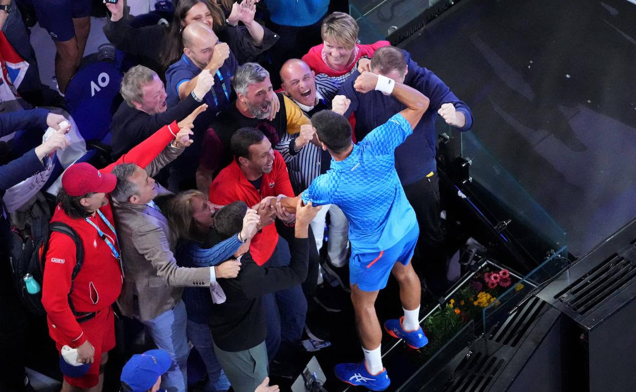 Gómez Herrera (con el polo rojo, en el centro) felicita a Djokovic (de espaldas) tras su hazaña en Melbourne. 