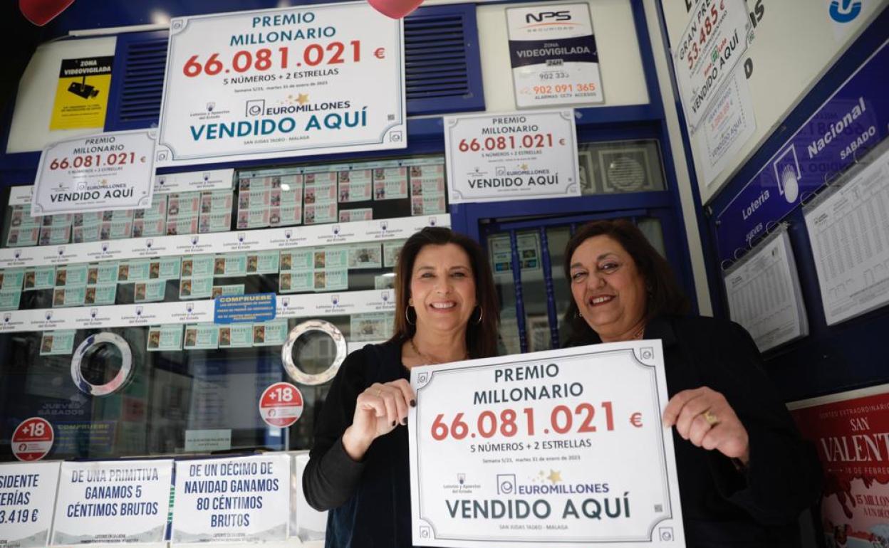 Begoña Jiménez y Mariló Gómez posan con el cartel que les acredita como la administración que ha dado el primer premio del sorteo Euromillones, en Málaga. 