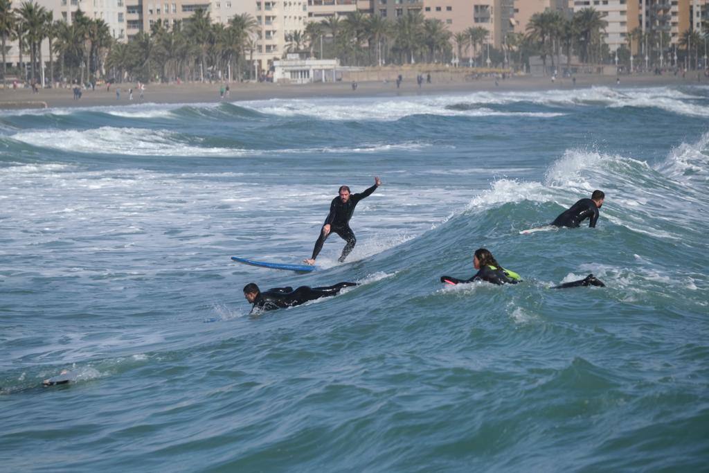 Tablas y ganas de coger olas en la playa de Huelin, este domingo. Surfistas aprovechan el viento de levante y la olas del temporal para meterse en el agua en distintos puntos de Málaga