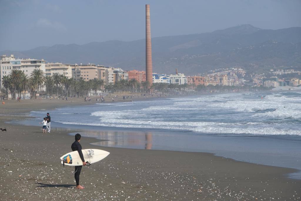 Tablas y ganas de coger olas en la playa de Huelin, este domingo. Surfistas aprovechan el viento de levante y la olas del temporal para meterse en el agua en distintos puntos de Málaga