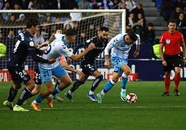 Dioni conduce un balón mientras Roberto intenta zafarse de la marca de Le Normand.