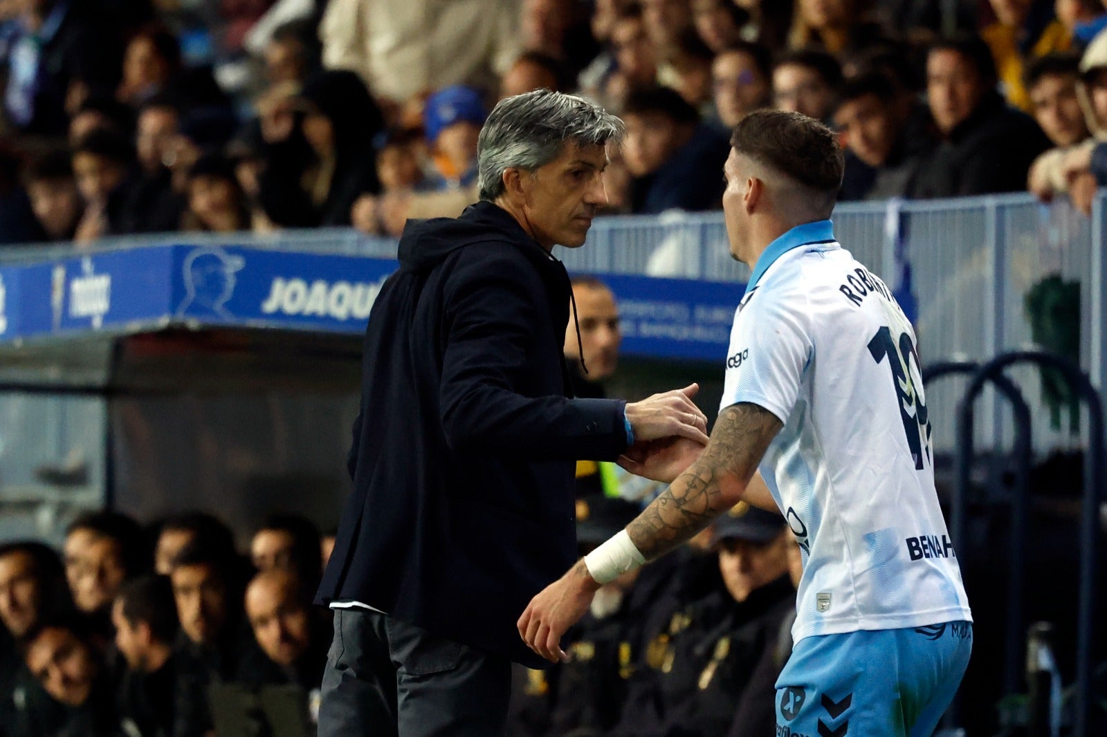 El entrenador de la Real Sociedad, Imanol Alguacil, choca la mano con Roberto durante un momento del partido.