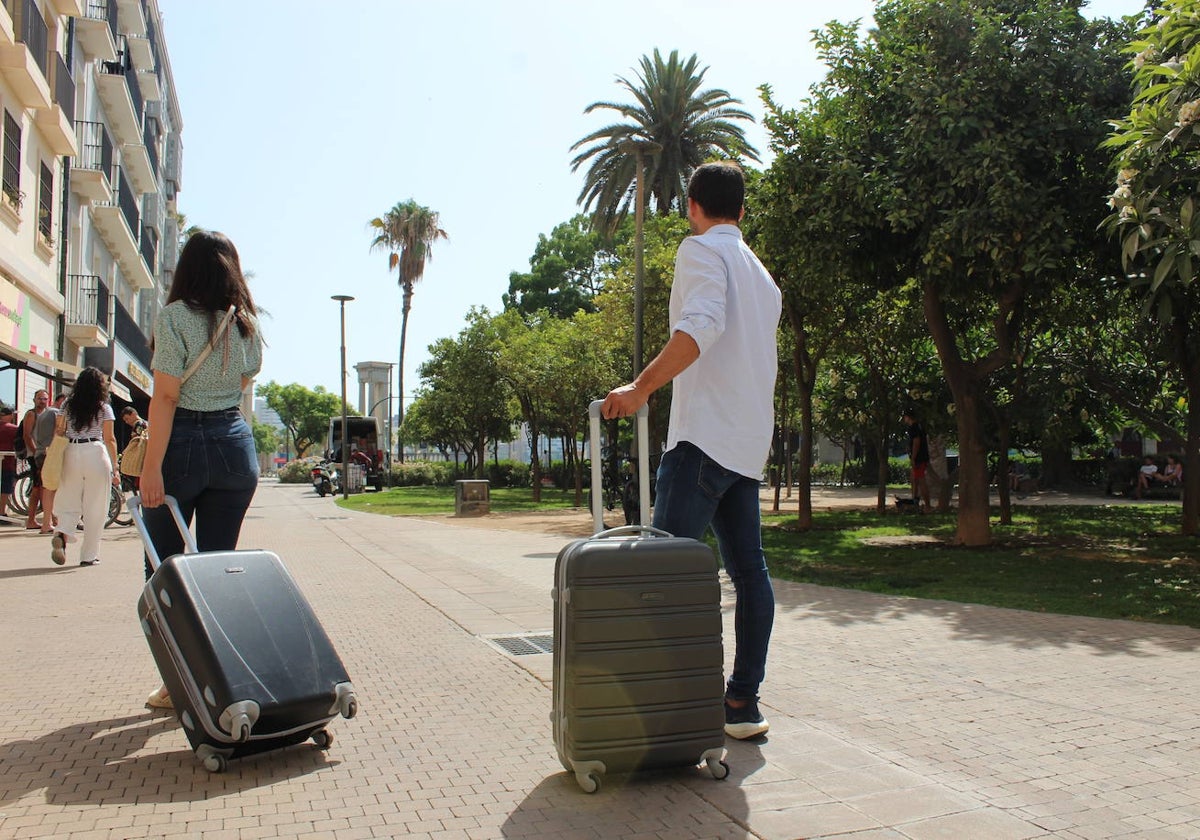 Turistas se dirigen hacia su alojamiento, en pleno centro de la capital malagueña.