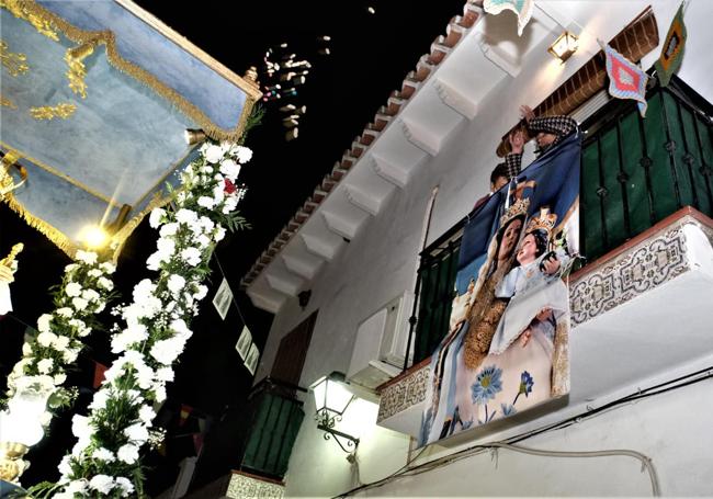 A su paso desde los balcones se arrojan peladillas y cacahuetes al trono.